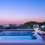 Jacuzzi éclairé sur une terrasse de l'Hôtel Villa Padulaccia au crépuscule, deux coupes et une coupelle de fraises sur le rebord