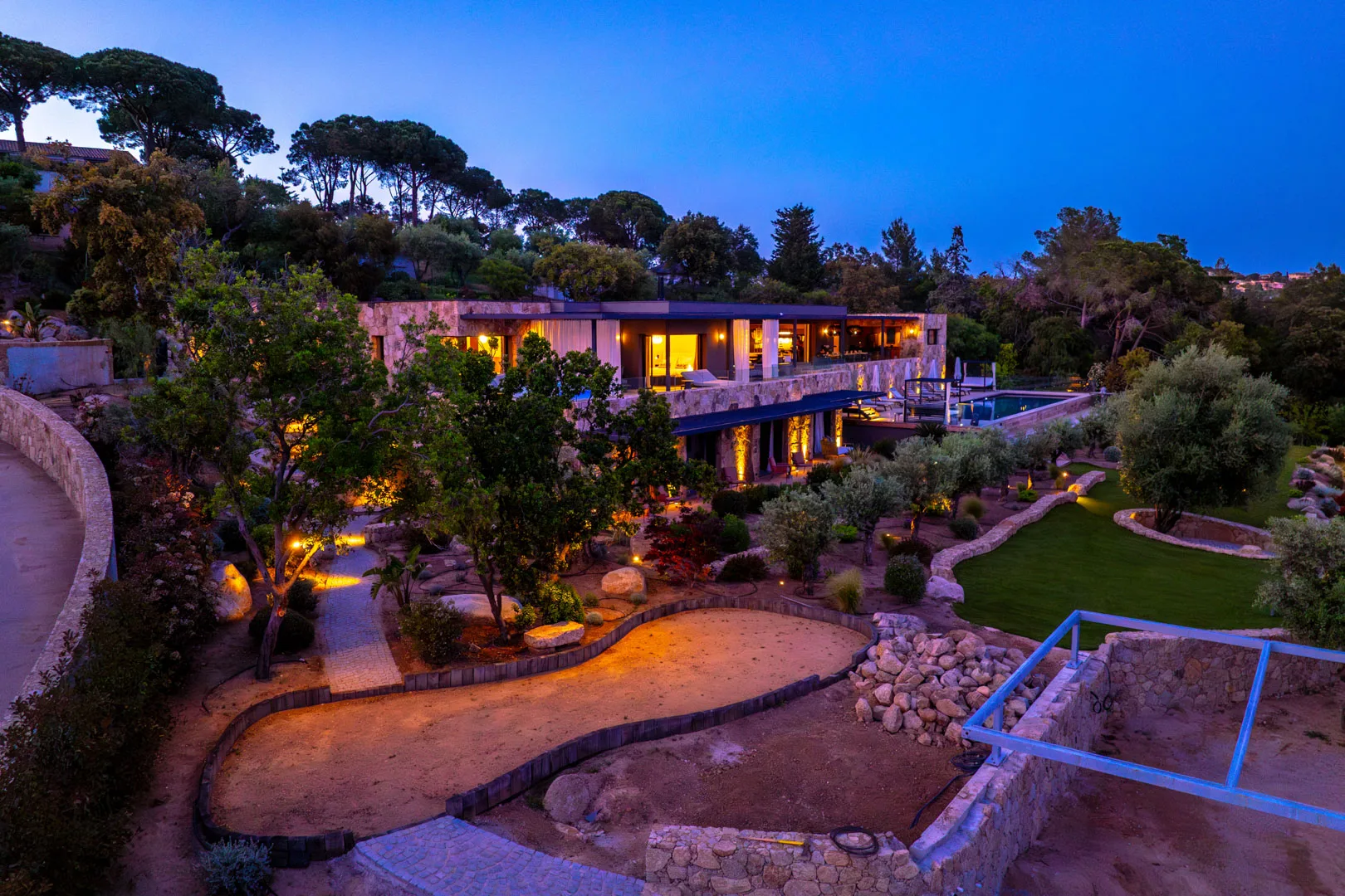 Jardin, allées de sable et façades de l'Hôtel Villa Padulaccia éclairés à l'heure bleue