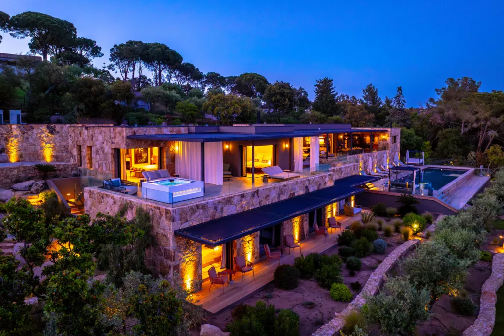 Façades de pierre et terrasses éclairées de l'Hôtel Villa Padulaccia à l'heure bleue