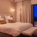 Chambre de l'Hôtel Villa Padulaccia à l'heure bleue, grand lit et baie vitrée ouverte sur la terrasse