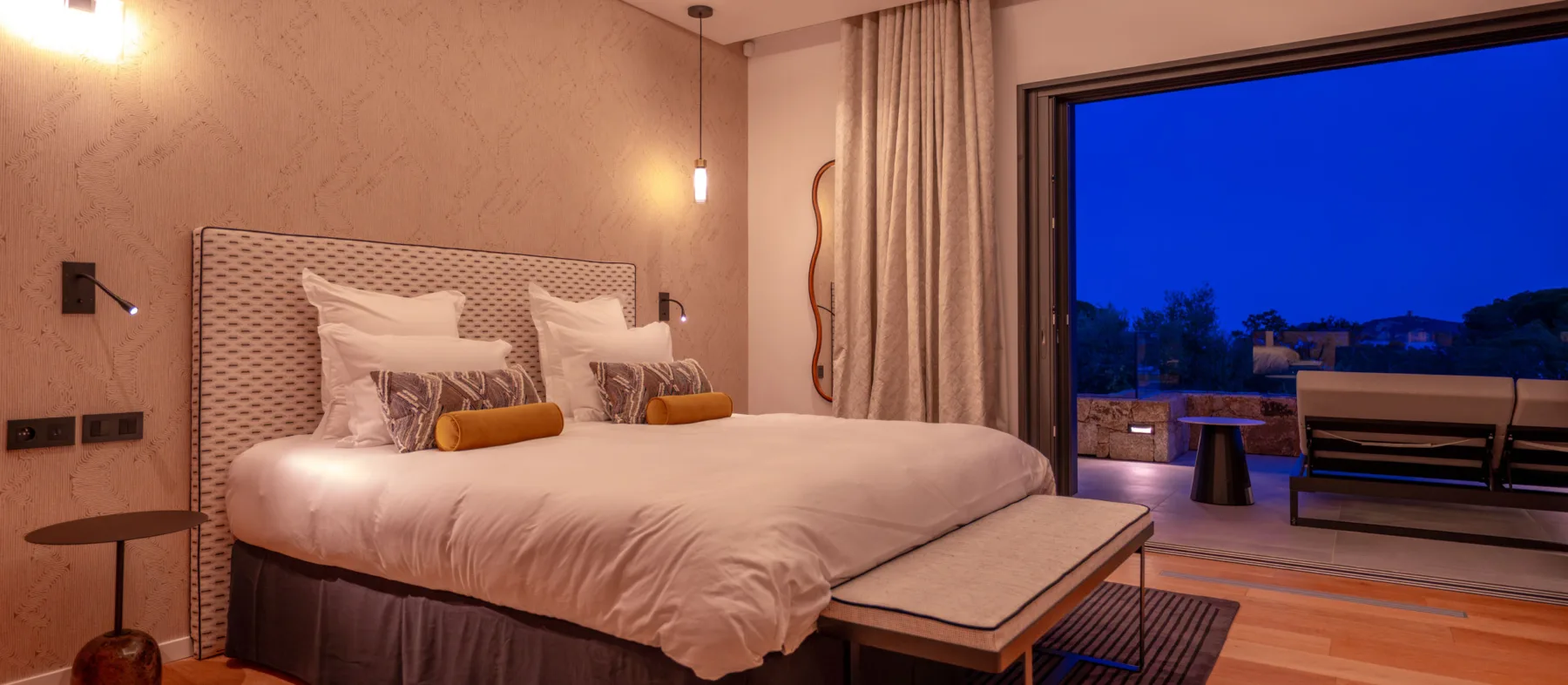 Chambre de l'Hôtel Villa Padulaccia à l'heure bleue, grand lit et baie vitrée ouverte sur la terrasse