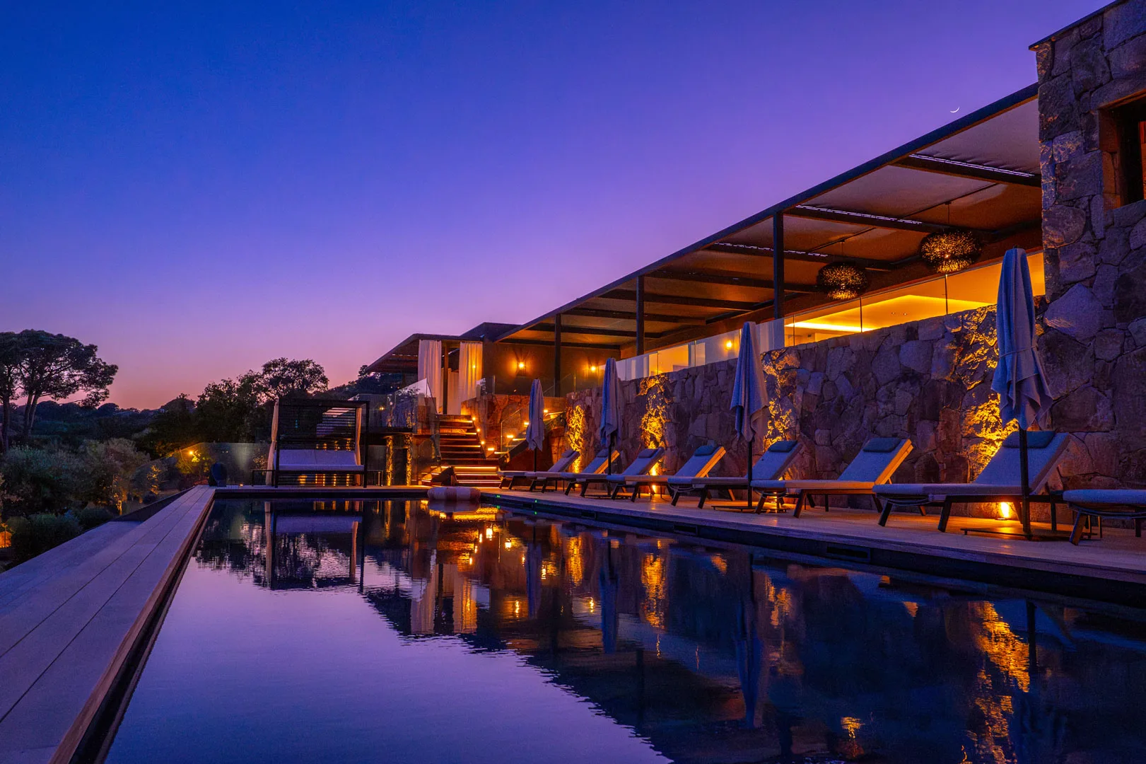 Piscine de l'Hôtel Villa Padulaccia au crépuscule, reflets des terrasses éclairées