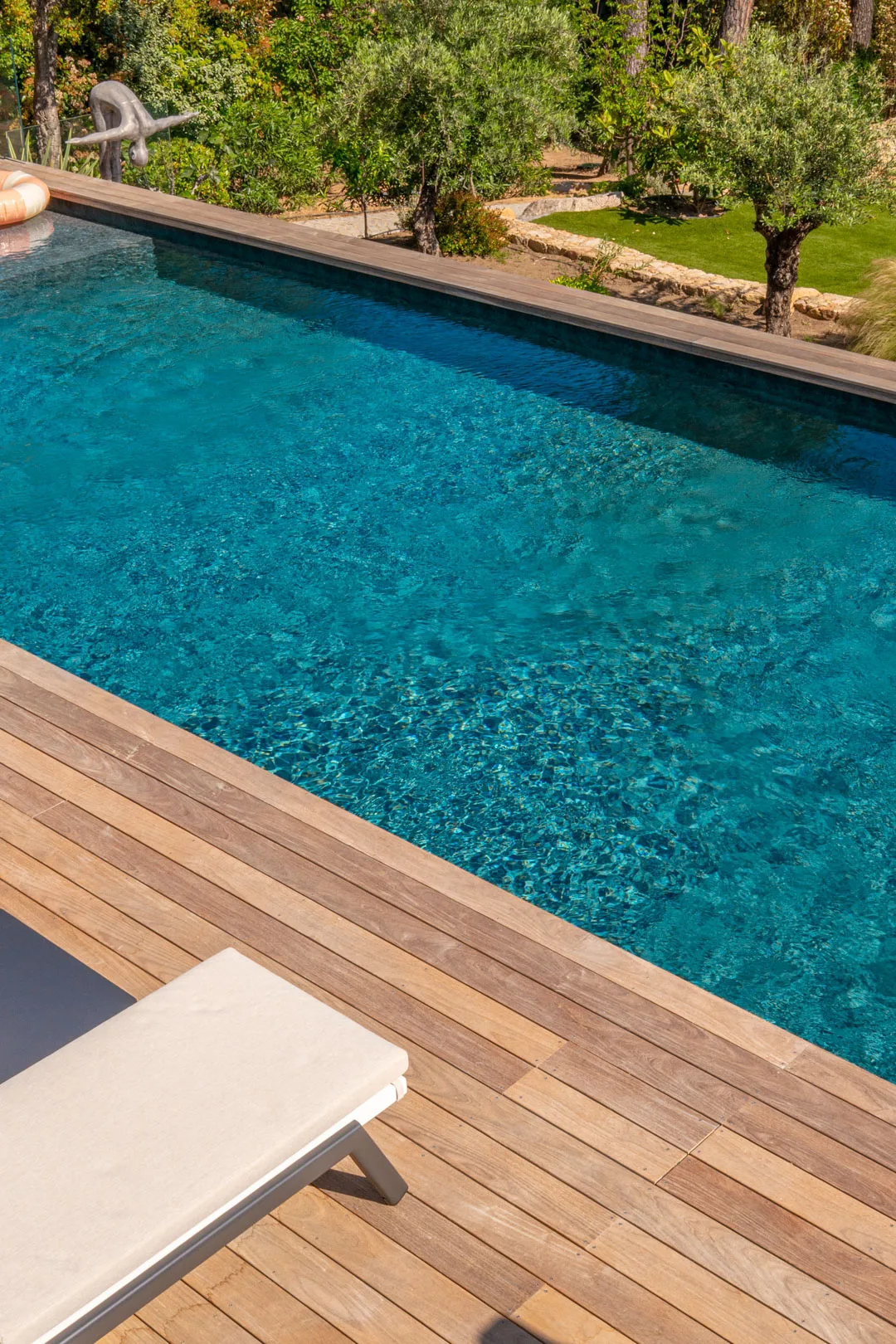 Bord de la piscine chauffée et terrasse en bois de l'Hôtel Villa Padulaccia, oliviers au-dessus du bassin