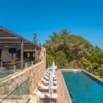 Piscine chauffée longeant la terrasse vitrée du salon de l'Hôtel Villa Padulaccia