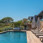 Transats, parasols et lit de repos le long de la piscine chauffée de l'Hôtel Villa Padulaccia