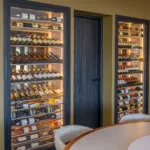Cave à vin vitrée et éclairée près de la table ronde de la salle à manger, Hôtel Villa Padulaccia