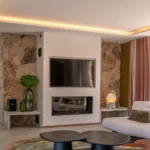 Coin salon de l'Hôtel Villa Padulaccia, cheminée encastrée, murs de pierre et tables basses