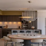 Salle à manger et cuisine de l'Hôtel Villa Padulaccia, grande table ronde sous une suspension en métal tressé