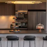Îlot de cuisine de l'Hôtel Villa Padulaccia avec tabourets, présentoir à gâteaux et cloche en verre