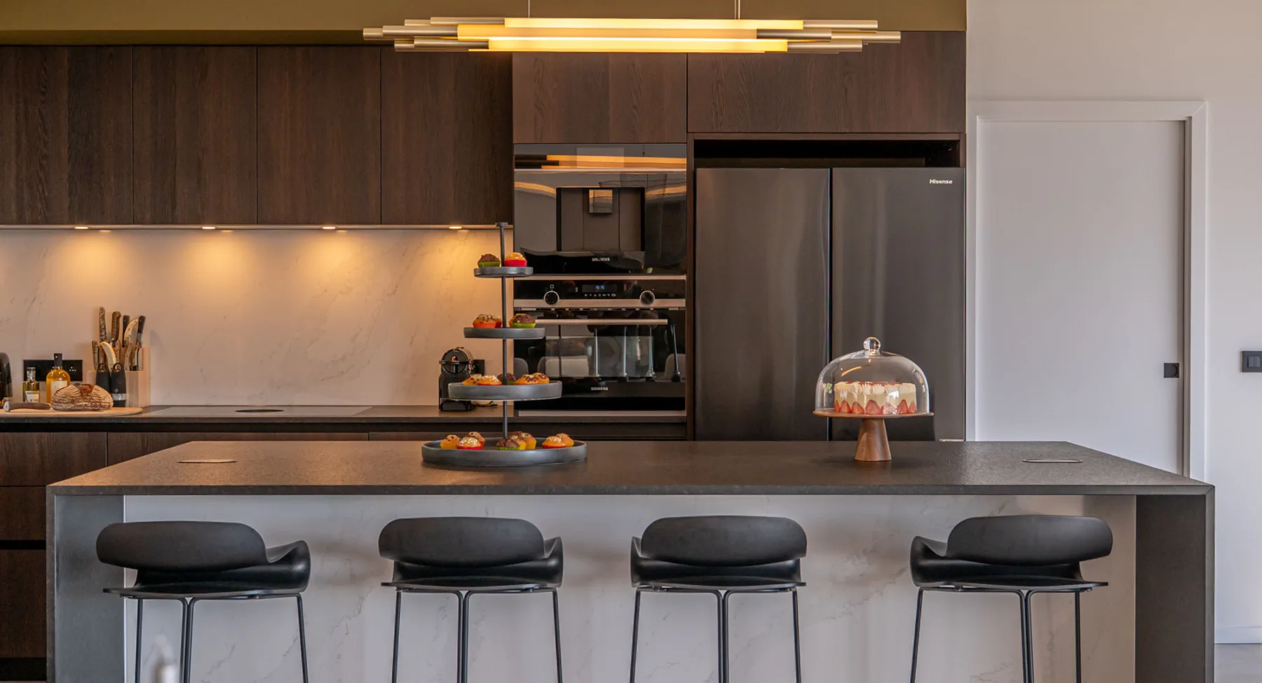 Îlot de cuisine de l'Hôtel Villa Padulaccia avec tabourets, présentoir à gâteaux et cloche en verre
