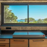 Plan de travail et four à pizza sous une fenêtre ouverte sur les pins et la mer, Hôtel Villa Padulaccia