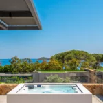Jacuzzi en bord de terrasse à l'Hôtel Villa Padulaccia, pins et mer en arrière-plan