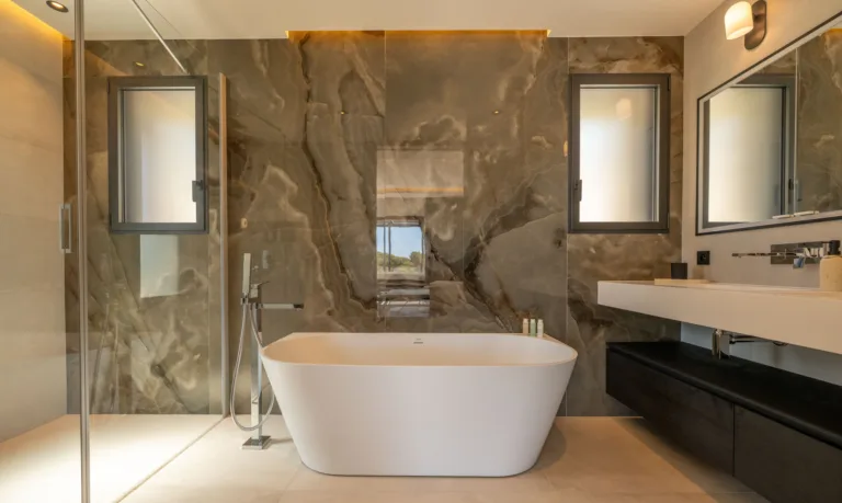 Salle de bain de la suite L'Amour, baignoire îlot devant un mur de marbre veiné