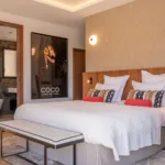 Suite L'Amour, lit et affiche encadrée, salle de bain visible par la porte ouverte