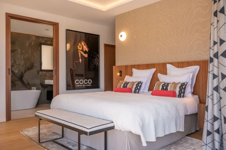 Suite L'Amour, lit et affiche encadrée, salle de bain visible par la porte ouverte
