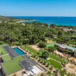 Vue aérienne de l'Hôtel Villa Padulaccia au milieu des pins, la côte et la mer turquoise au loin