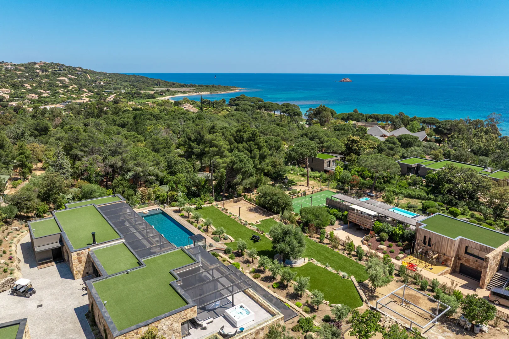 Vue aérienne de l'Hôtel Villa Padulaccia au milieu des pins, la côte et la mer turquoise au loin
