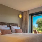 Chambre Mon Paradis, lit et baie ouverte sur les oliviers et la terrasse