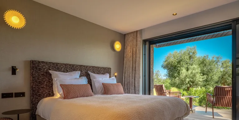 Chambre Mon Paradis, lit et baie ouverte sur les oliviers et la terrasse