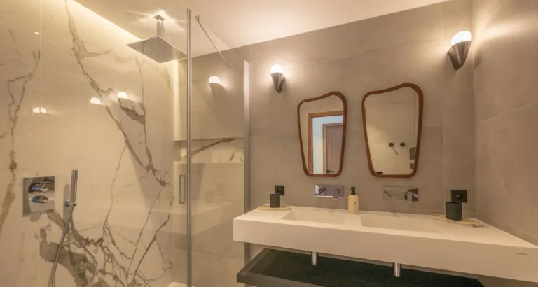 Salle de bain de la chambre Mon Paradis, douche en marbre blanc et double vasque
