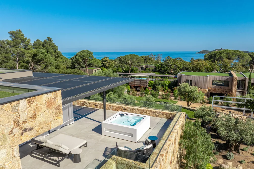 Jacuzzi et lit de repos sur un toit-terrasse de l'Hôtel Villa Padulaccia, la mer au loin