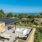 Jacuzzi et lit de repos sur un toit-terrasse de l'Hôtel Villa Padulaccia, la mer au loin