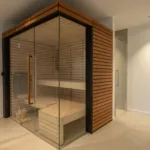 Sauna en bois clair à parois vitrées du spa de l'Hôtel Villa Padulaccia
