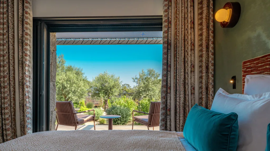 Chambre Bouquet de Roses de l'Hôtel Villa Padulaccia, lit et baie ouverte sur une terrasse et le jardin