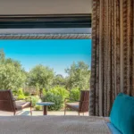Chambre Bouquet de Roses de l'Hôtel Villa Padulaccia, lit et baie ouverte sur une terrasse et le jardin